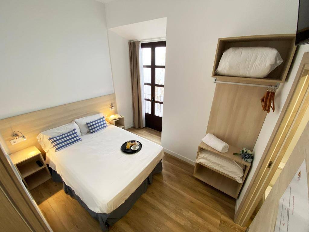 Habitación con cama doble, armario y balcón